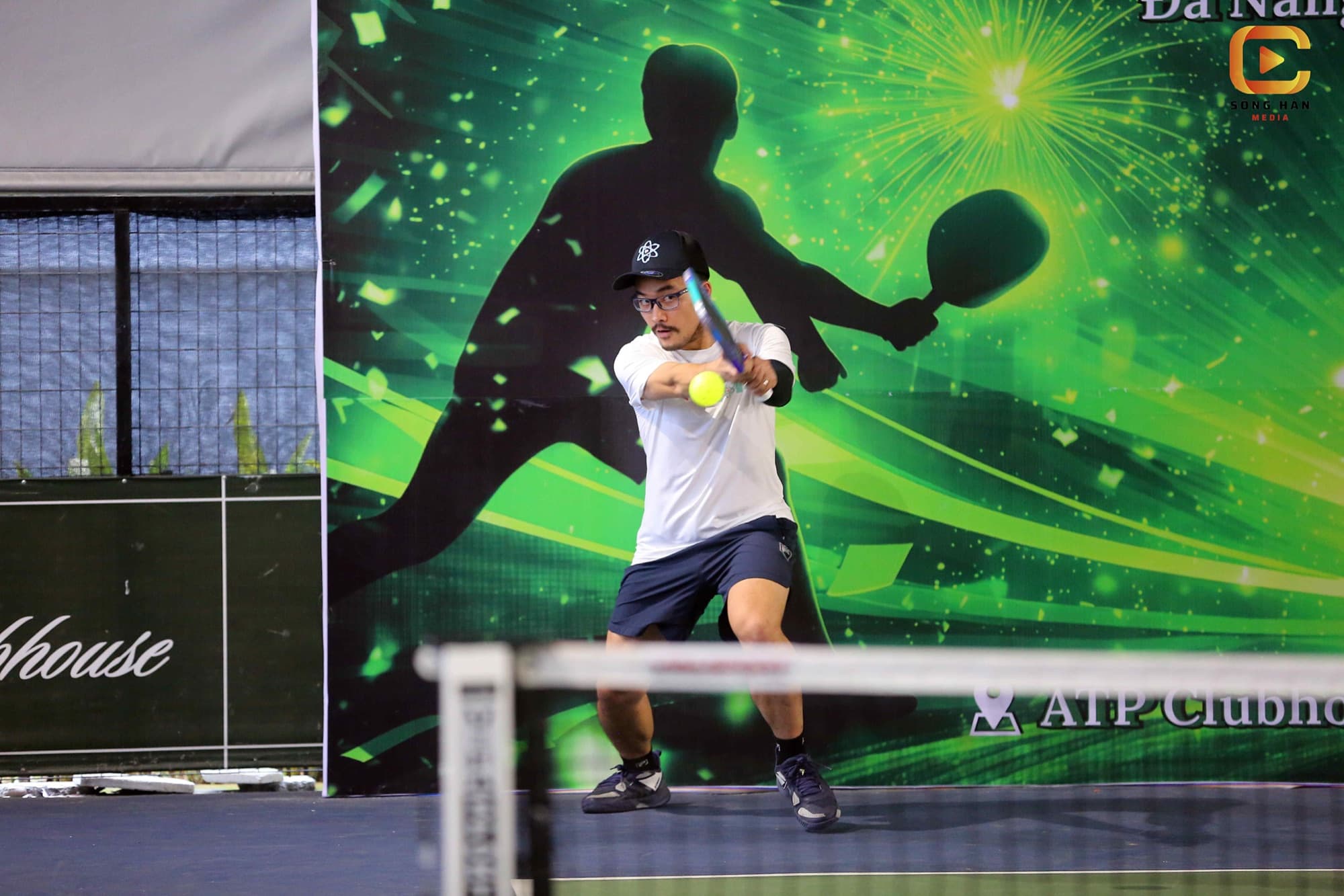 Coach Ho playing a forehand on an outdoor pickleball court in Da Nang, Vietnam