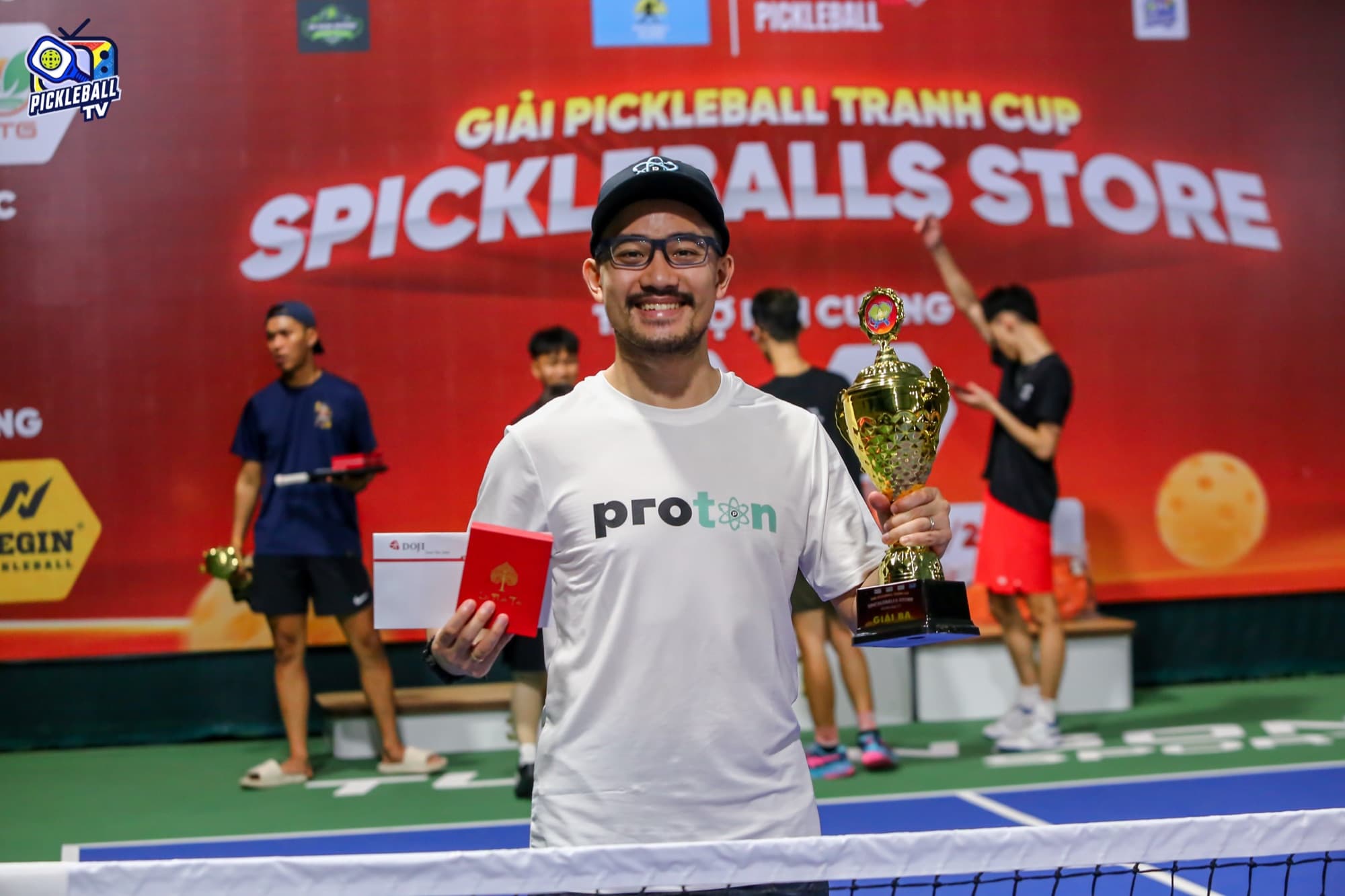 Coach Ho holding a winner's trophy at a Da Nang pickleball tournament